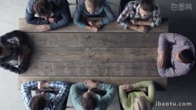 现代商务会议的概念人们穿着休闲装，围着木桌坐着，竖起大拇指